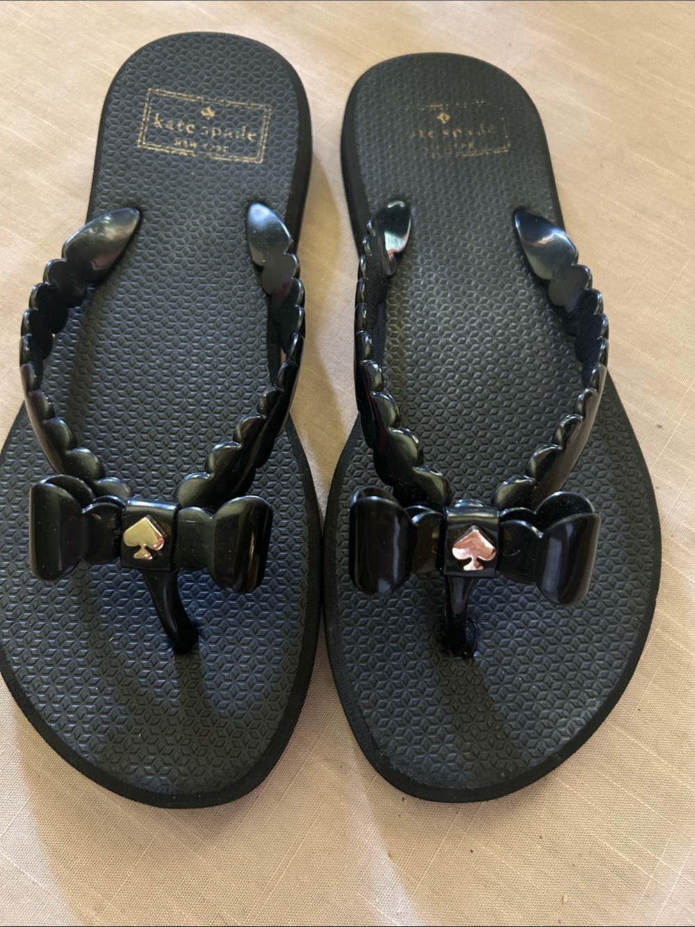 Kate Spade black flip flops with signature gold heart